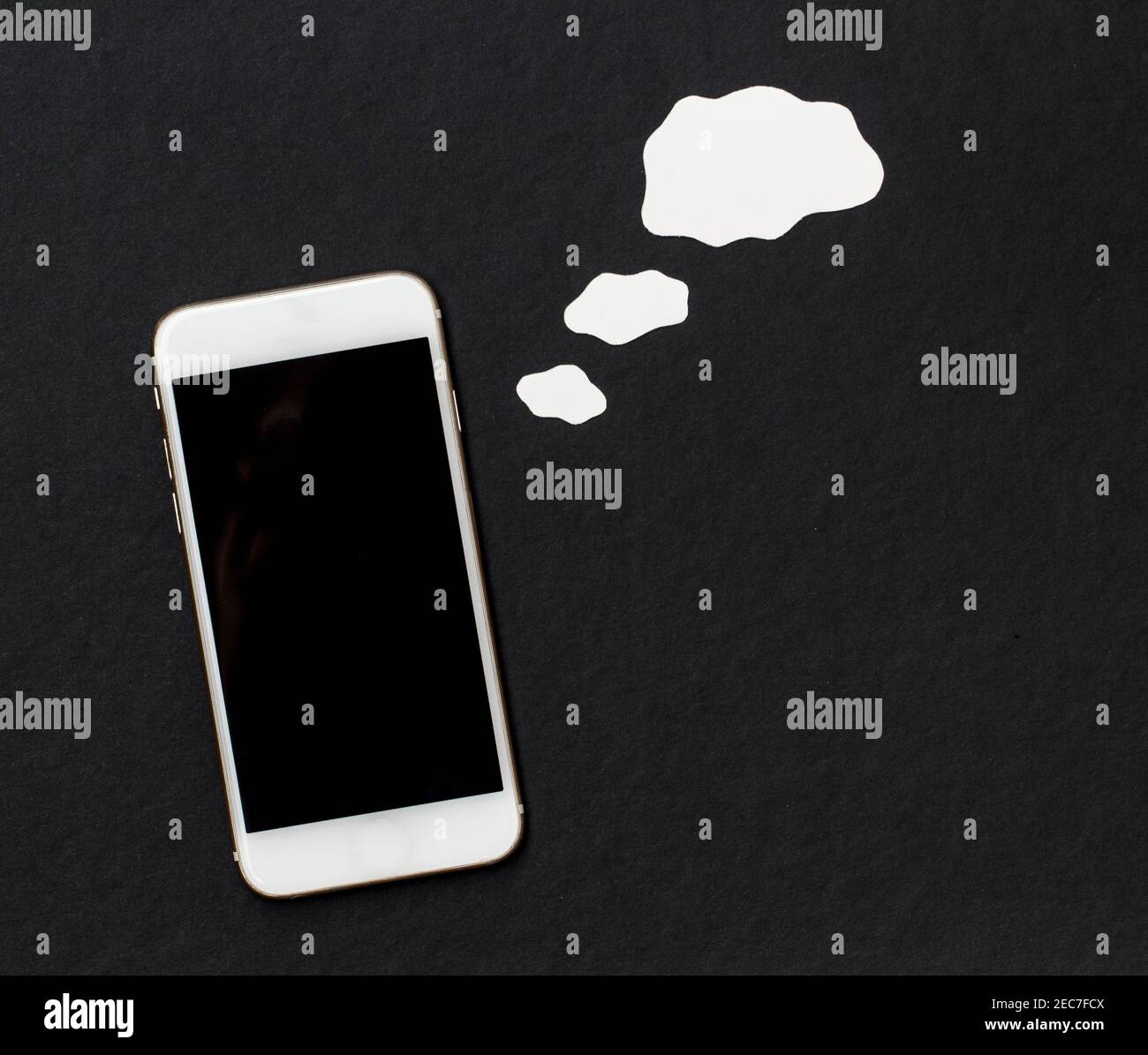 Weißes Telefon mit leeren obwohl Blase auf schwarzem Hintergrund. Smartphone mit Black Screen Banner Vorlage. Handy und leere Cloud. Flach liegend komposi Stockfoto
