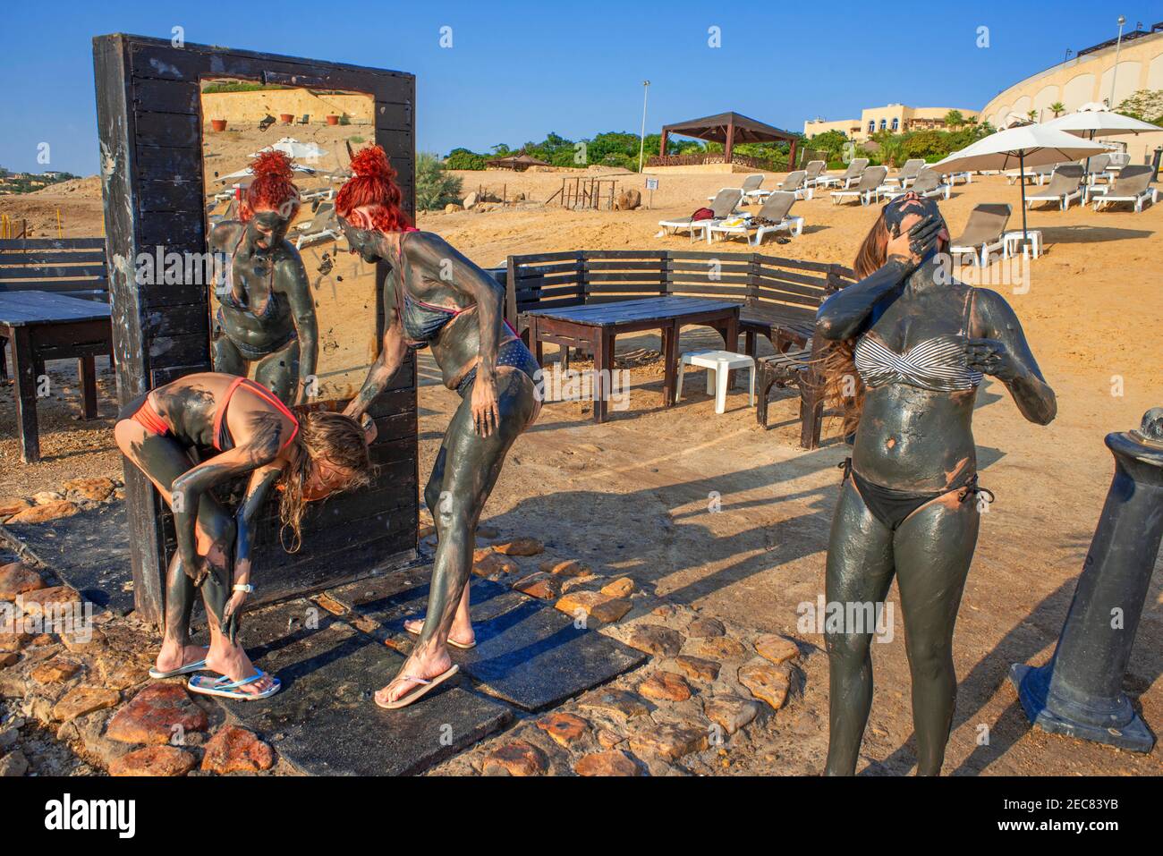 Menschen in schwarzem Schlamm und Salze des Toten Meeres bedeckt, dass Haben therapeutische heilende Eigenschaften, die bei Crowne sehr vorteilhaft sind Plaza Dead Sea Hotel in t Stockfoto