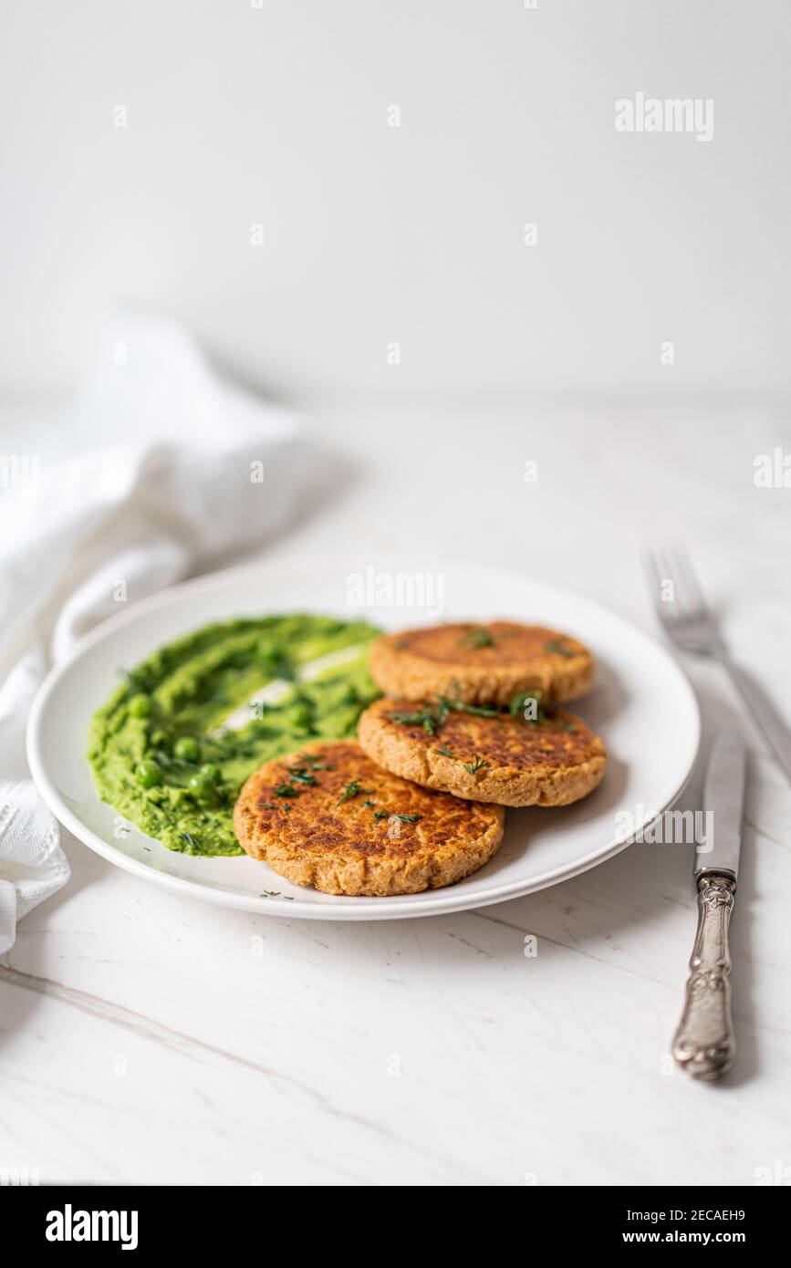 Blumenkohlkartoffeln mit Parmesan-Käse und Erbsen-Püree Stockfoto