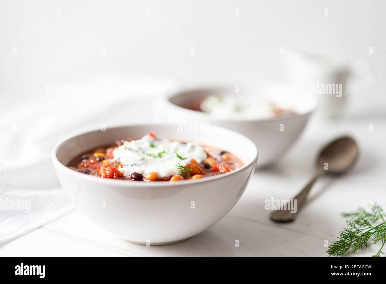 Gemüsebesen-Eintopf mit roten Bohnen, Tomaten, Zuckermais, roten und gelben Paprika auf flachem Lay Stockfoto