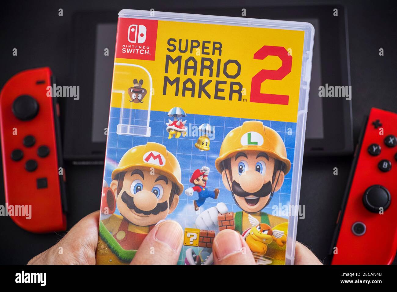 Tambow, Russische Föderation - 24. Januar 2021 EIN Mann hält ein Super Mario Maker 2 Videospiel in Kunststoffkoffer für die Nintendo Switch Konsole. Stockfoto