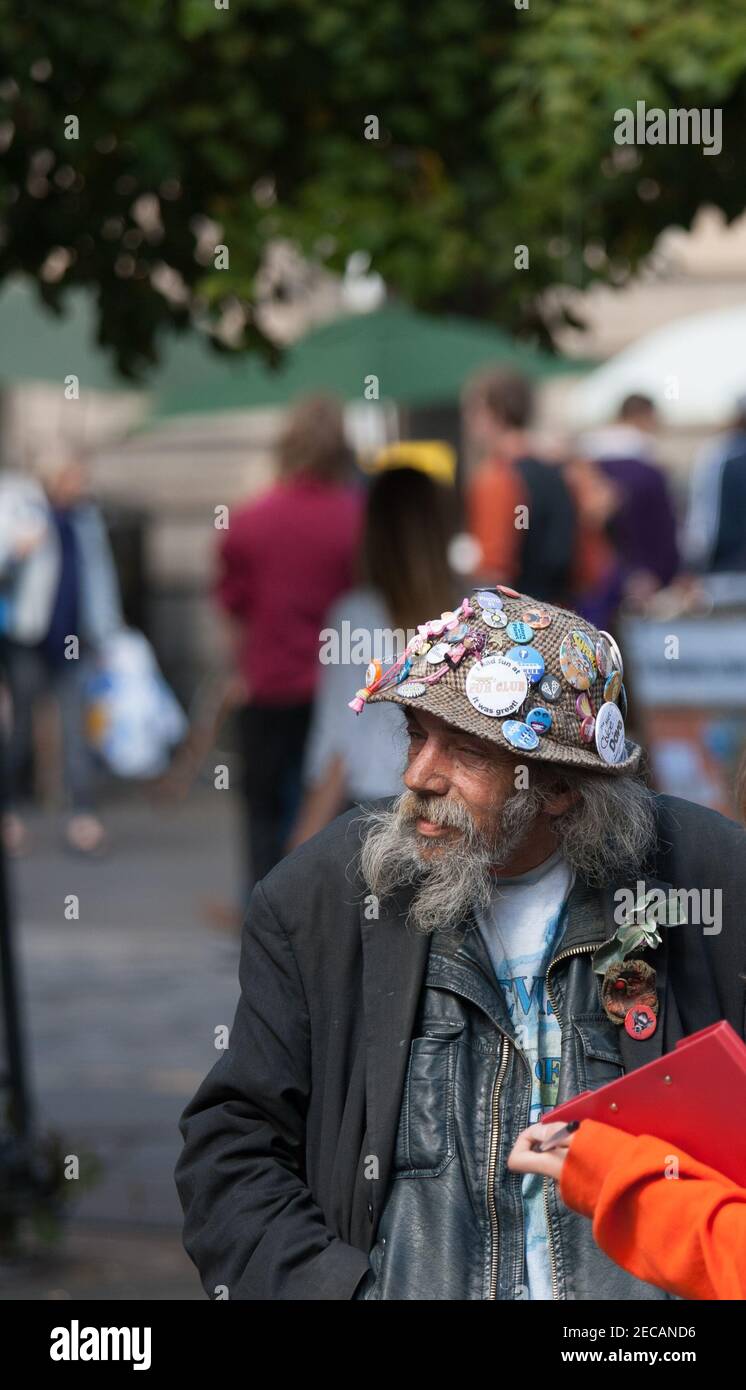 Ein alter Mann mit weißem Bart und einem Hut mit Abzeichen. Stockfoto