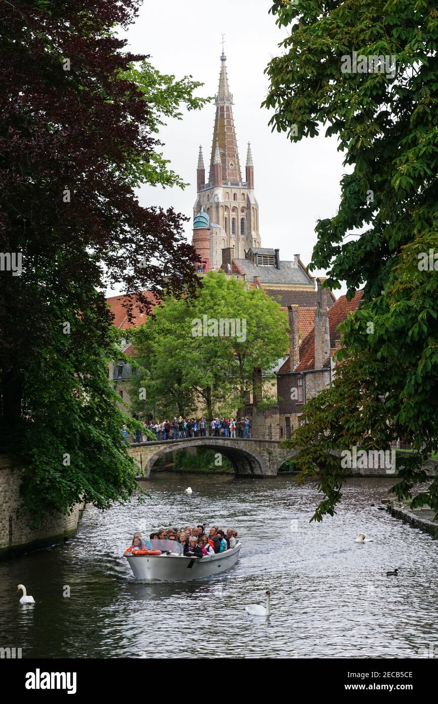 Touristen auf einer Brücke über den Bakkersrei-Kanal mit dem Turm der Liebfrauenkirche im Hintergrund, Brügge, Belgien Stockfoto