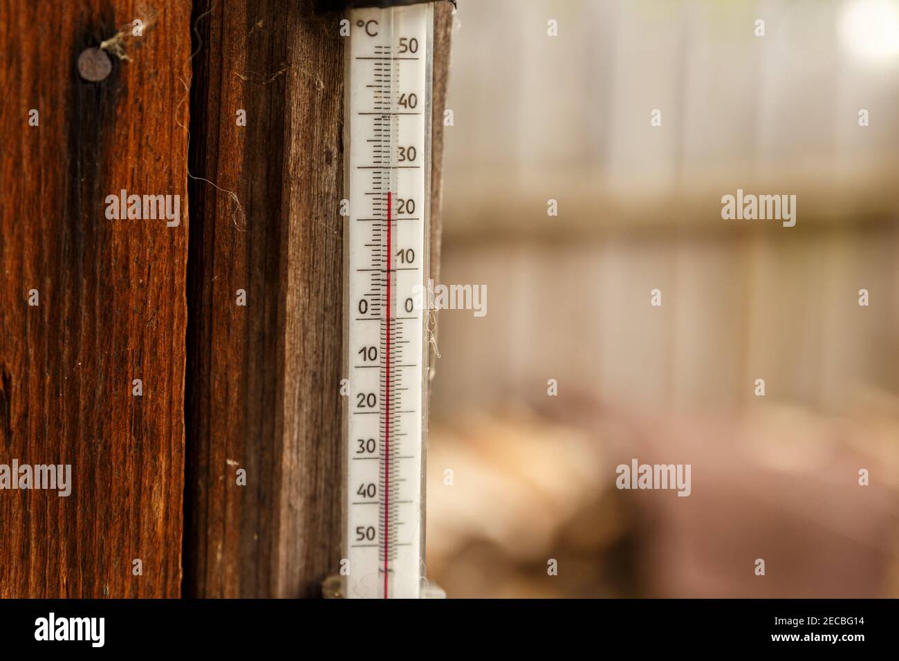 Ein Straßenthermometer hängt an der Wand eines Holzhauses. Stockfoto