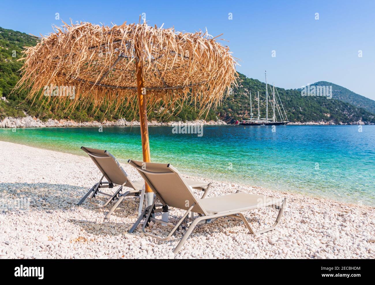 Kefalonia, Griechenland. Liege und Sonnenschirm am Strand von Antisamos. Stockfoto