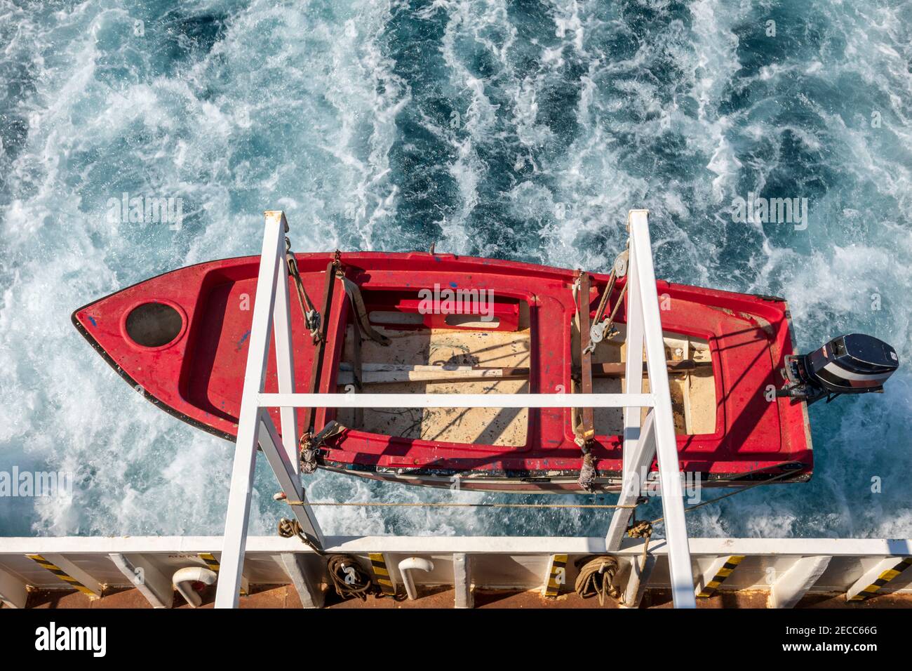 Rotes Rettungsboot, das über dem Meer an einer Fähre hängt. Stockfoto