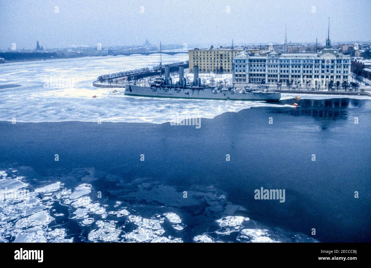 1990 Archivfoto des Cruiser Aurora über den gefrorenen Fluss Bolshaya Nevka und den Fluss Neva in Leningrad, jetzt St. Petersburg, Russland. Stockfoto