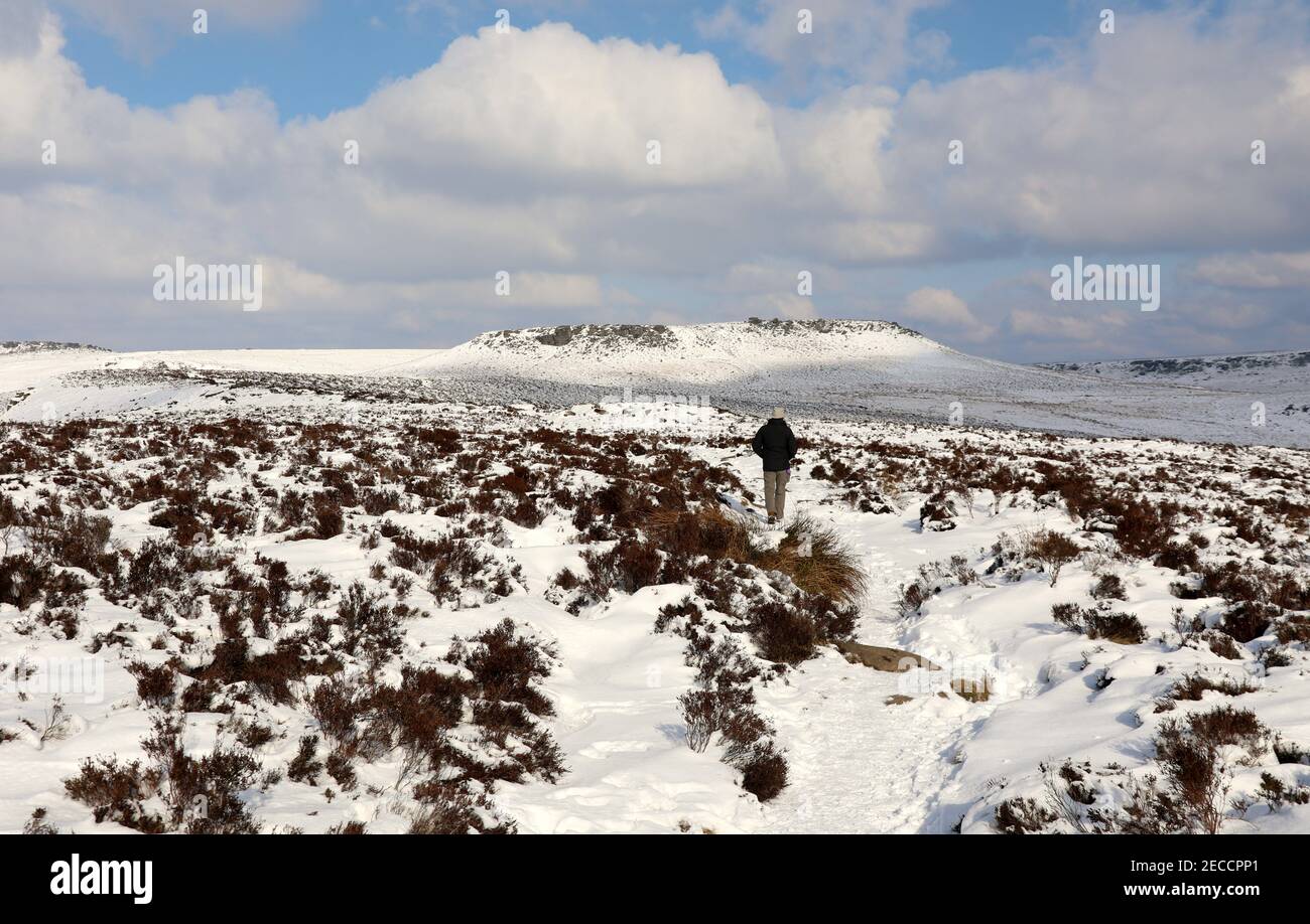 Moorwanderung zu einem schneebedeckten Higger Tor von über Owler Tor im Peak District Stockfoto