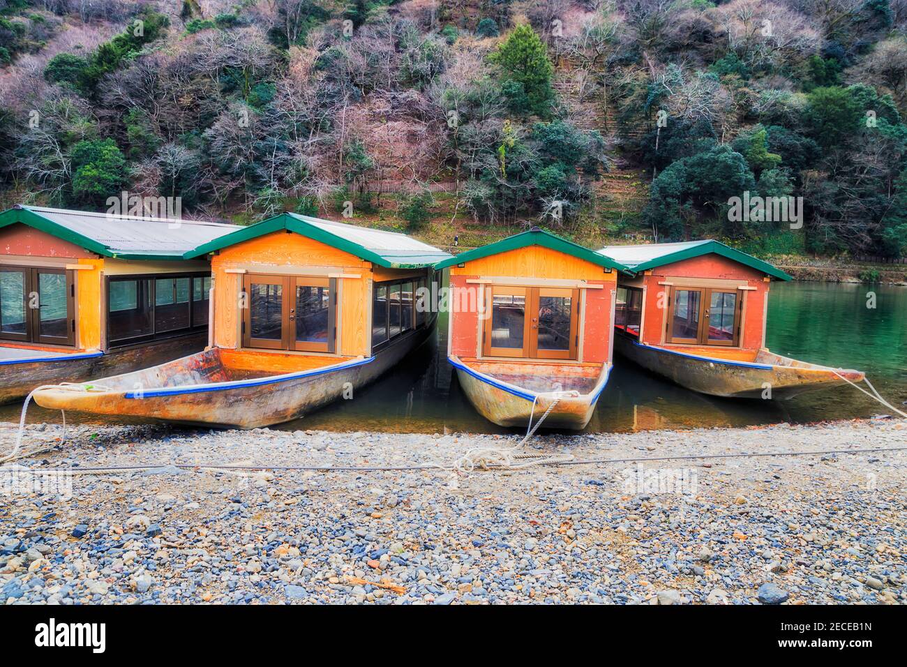 Touristenboote auf dem Katsura-Fluss vor dem Arashiyama-Berg in Kyoto, Japan. Stockfoto