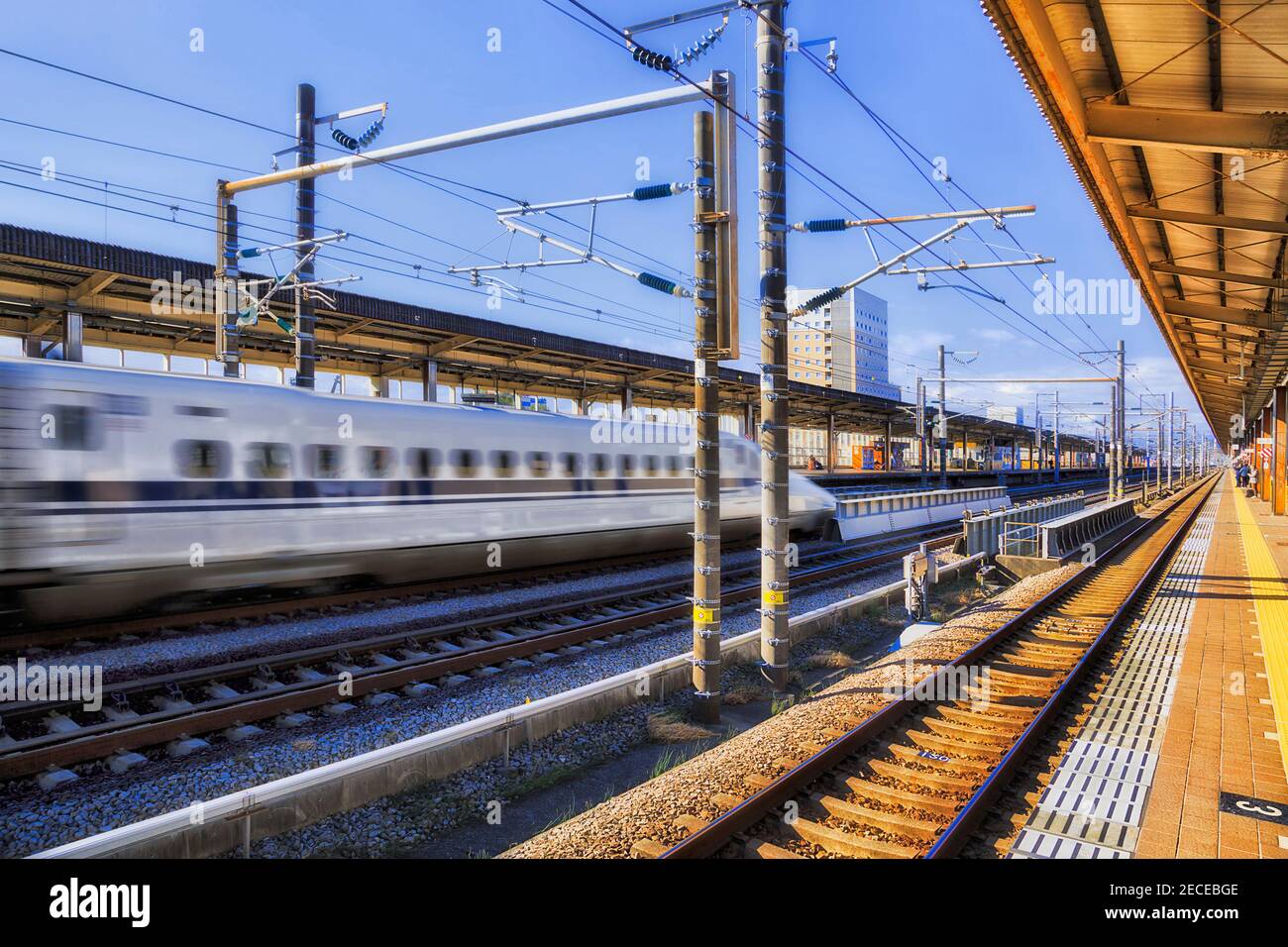 Verschwommener Hochgeschwindigkeitszug, der durch den Bahnhof Shin-Fuji mit einer Geschossgeschwindigkeit fährt - verschwommen. Stockfoto