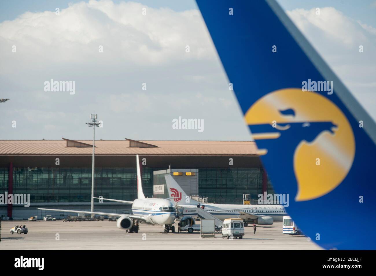 Ein Flugzeug der Air China wird auf dem Vorfeld geparkt, während ein Flügelchen der Mongolian Airlines mit seinem Logo an einem Tag ohne Umweltverschmutzung am Beijing Capital Airport im Shunyi-Bezirk der chinesischen Hauptstadt Peking, China, VR China, vorbeifährt. © Time-Snaps Stockfoto