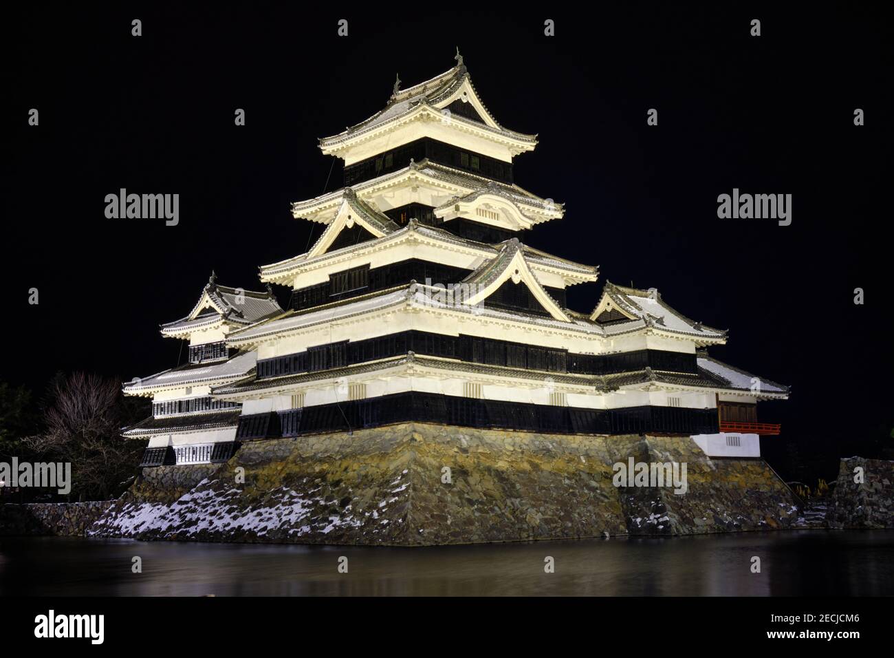 Das Schloss Matsumoto, in der Nacht im Winter in Weiß beleuchtet Stockfoto