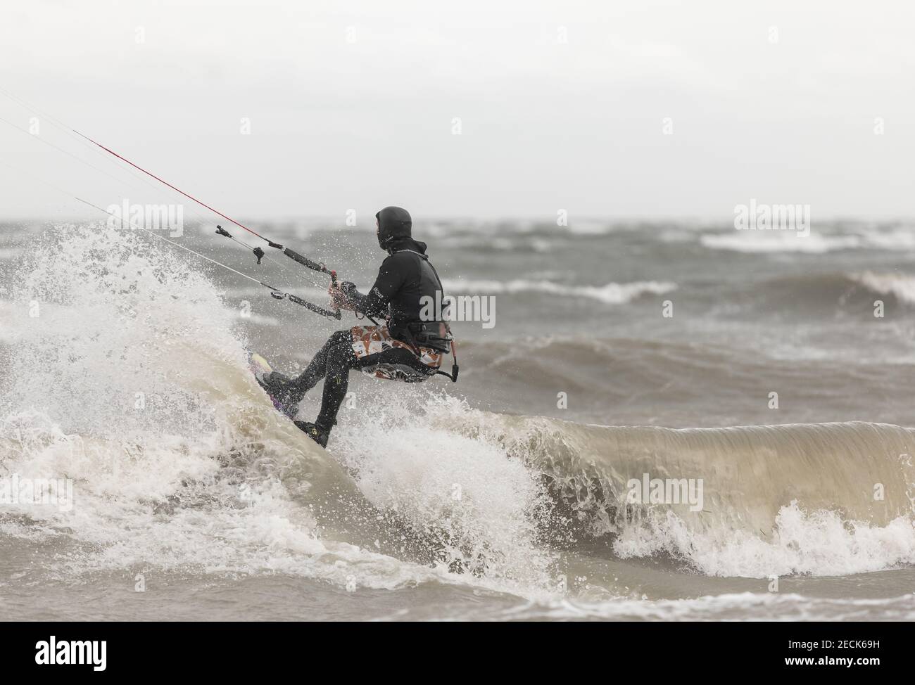 Ein Kiteboarder, der an einem regnerischen Tag auf den Wellen im Meer reitet. Boundary Bay, BC, Kanada-November 17,2020. Selektiver Fokus, Sportfoto, Reisefoto. Stockfoto