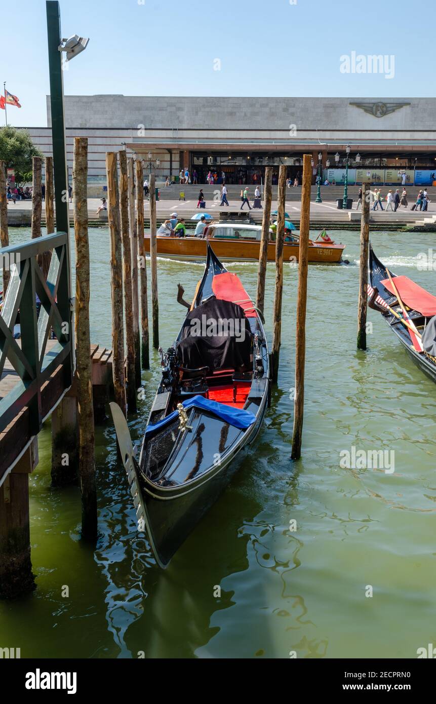 Leere Gondel links zwischen den Pylonen im Wasser des Canale Grande, Venedig, Italien. Stockfoto