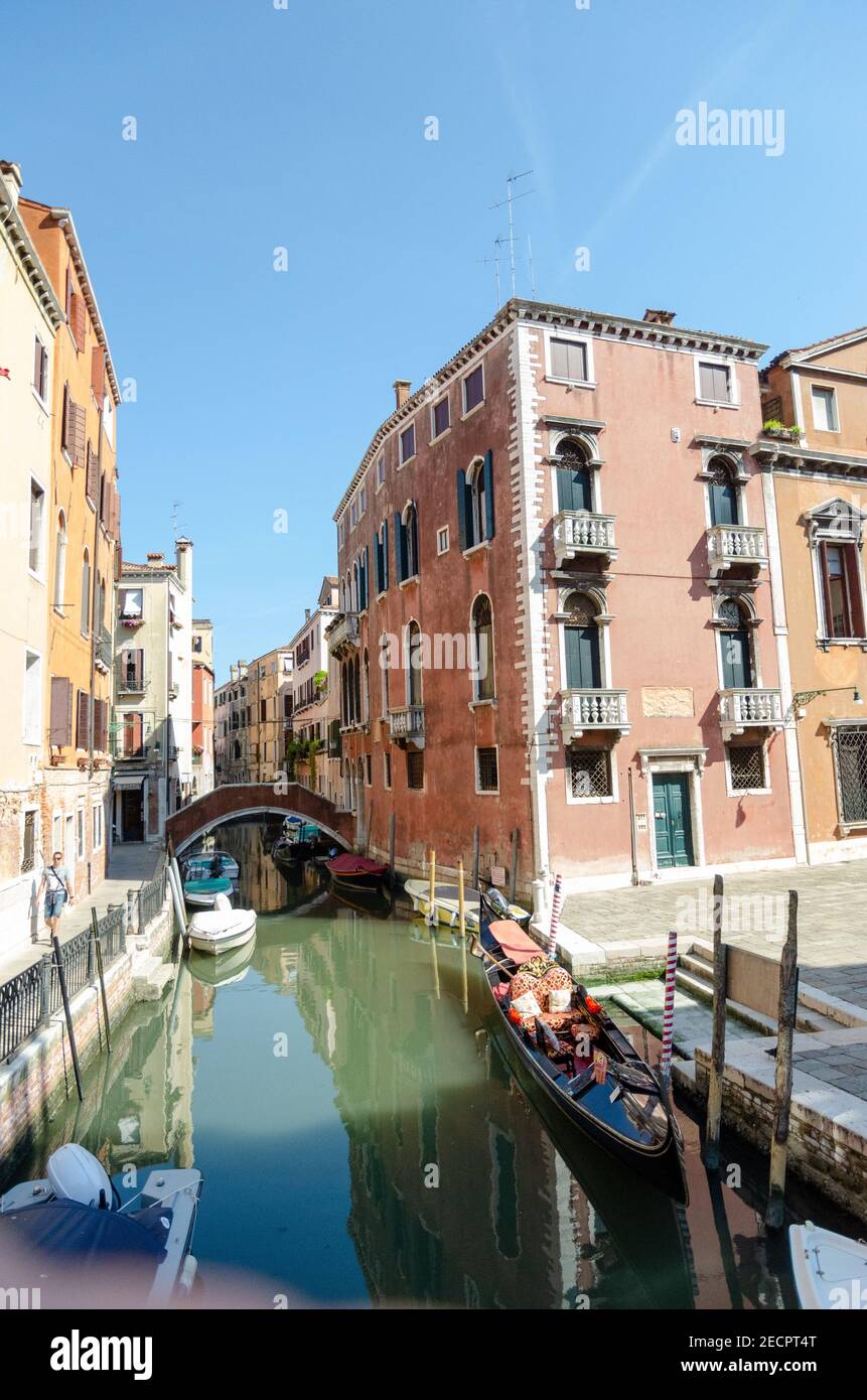 Leere Gondel links zwischen den Pylonen im Wasser des Kanals, Venedig, Italien. Stockfoto