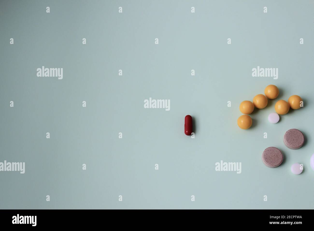 Bunte Vitamintabletten, Medikamententabletten und Kapseln auf abstrakt grünem Hintergrund. Stockfoto