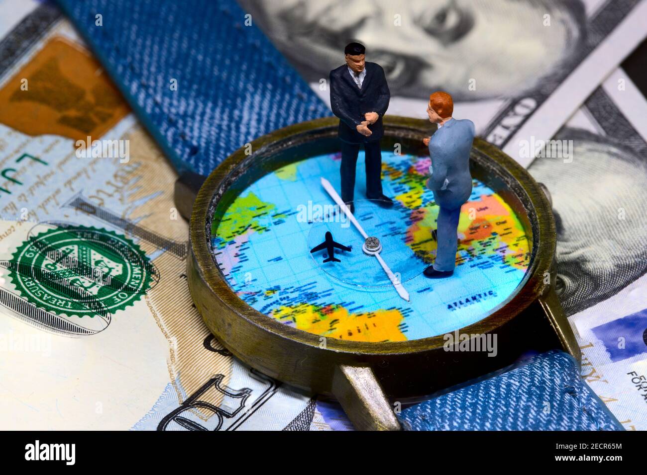 Zwei Geschäftsleute Figuren auf Zeit und Geld Hintergrund. Weltweites Geschäftskonzept. Internationale Geschäftsvereinbarung. Globales Unternehmen strategische Par Stockfoto