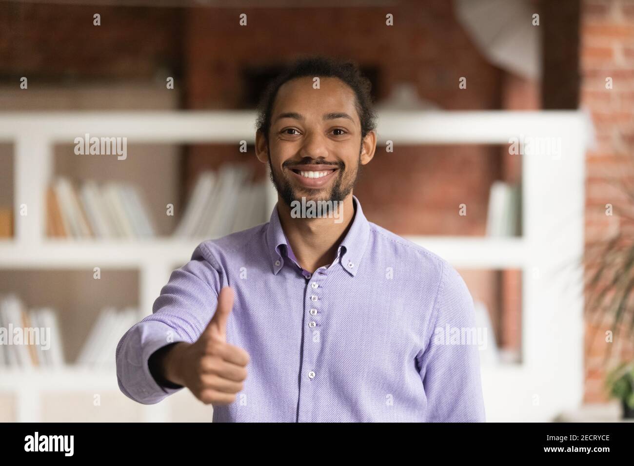 Porträt von lächelnden ethnischen Mann zeigen Daumen nach oben Stockfoto