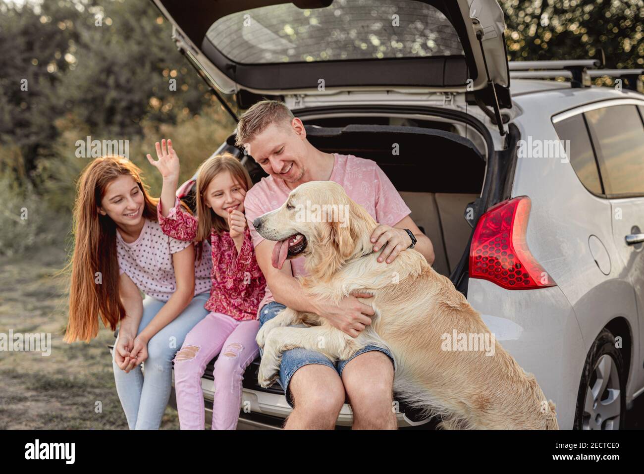 Vater mit Töchtern und Hund im Auto Stockfoto