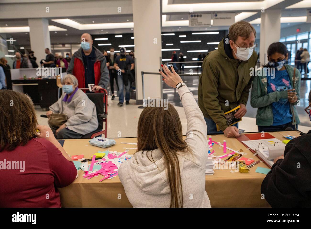 Frau führt einen potenziellen Patienten zum Check-in-Tisch, damit er möglicherweise einen Impfstoff gegen die Coronavirus-Krankheit (COVID-19) erhalten kann.Risikopersonen, die mindestens 65 Jahre alt sind, erhielten im Charleston Convention Center und im Coliseum vorrangig einen Impfstoff gegen die Coronavirus-Krankheit (COVID-19). Es wurde geschätzt, dass irgendwo zwischen 5.000 und 6.000 Menschen einen Coronavirus-Impfstoff (COVID-19) erhalten würden, was dieses Ereignis zum größten Impfereignis macht, das Kanawha County, West Virginia je gesehen hat. Sowohl der Pfizer- als auch der Moderna-Impfstoff waren für ältere Personen oder Menschen mit Kompromi zur Verfügung Stockfoto