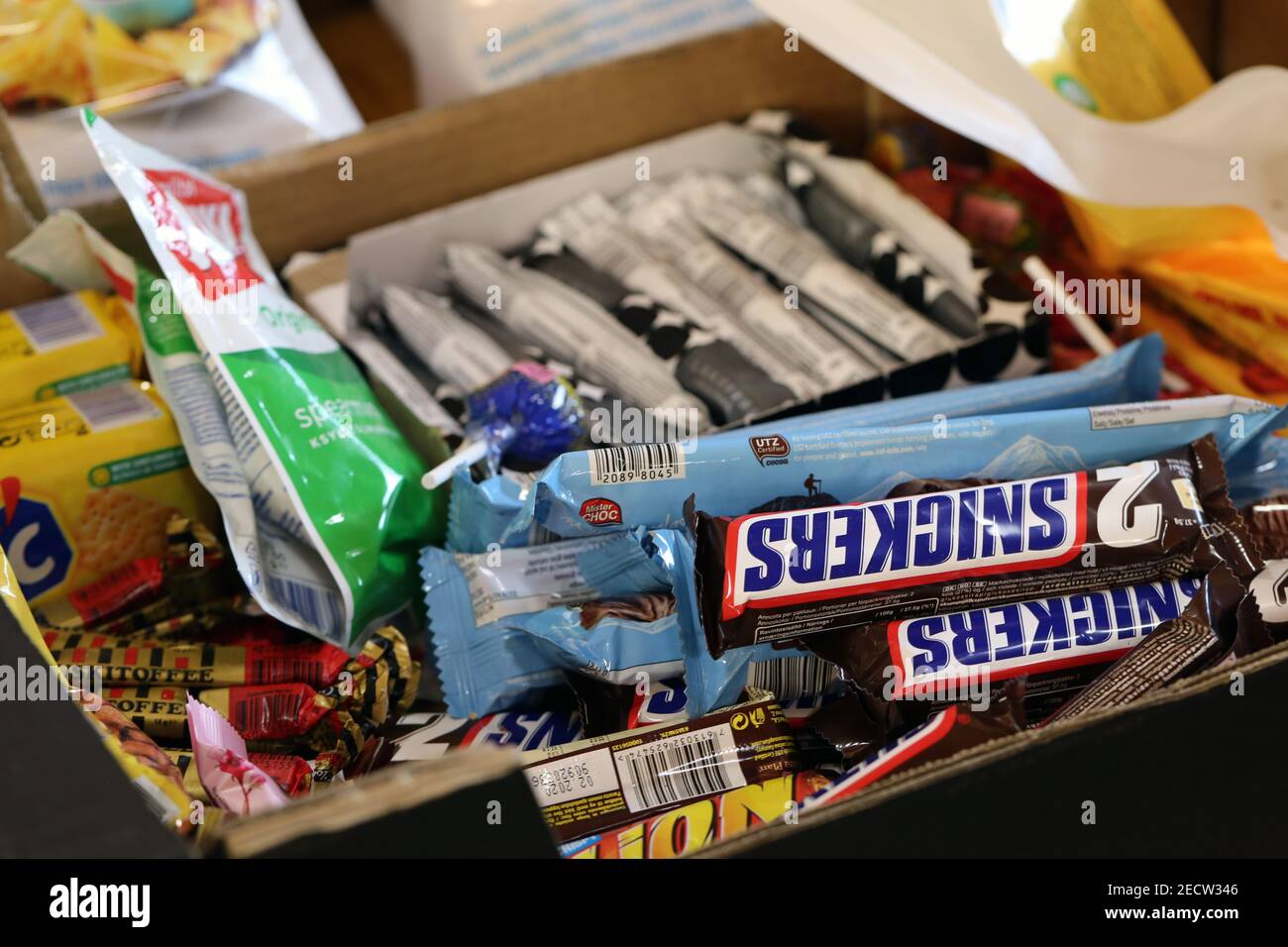 Viele verschiedene Pralinen, Süßigkeiten und Kaugummis in einer Schachtel, die fertig zum Verzehr ist. Ungesunde, aber leckere Snacks. Nahaufnahme Farbbild, keine Menschen. Stockfoto