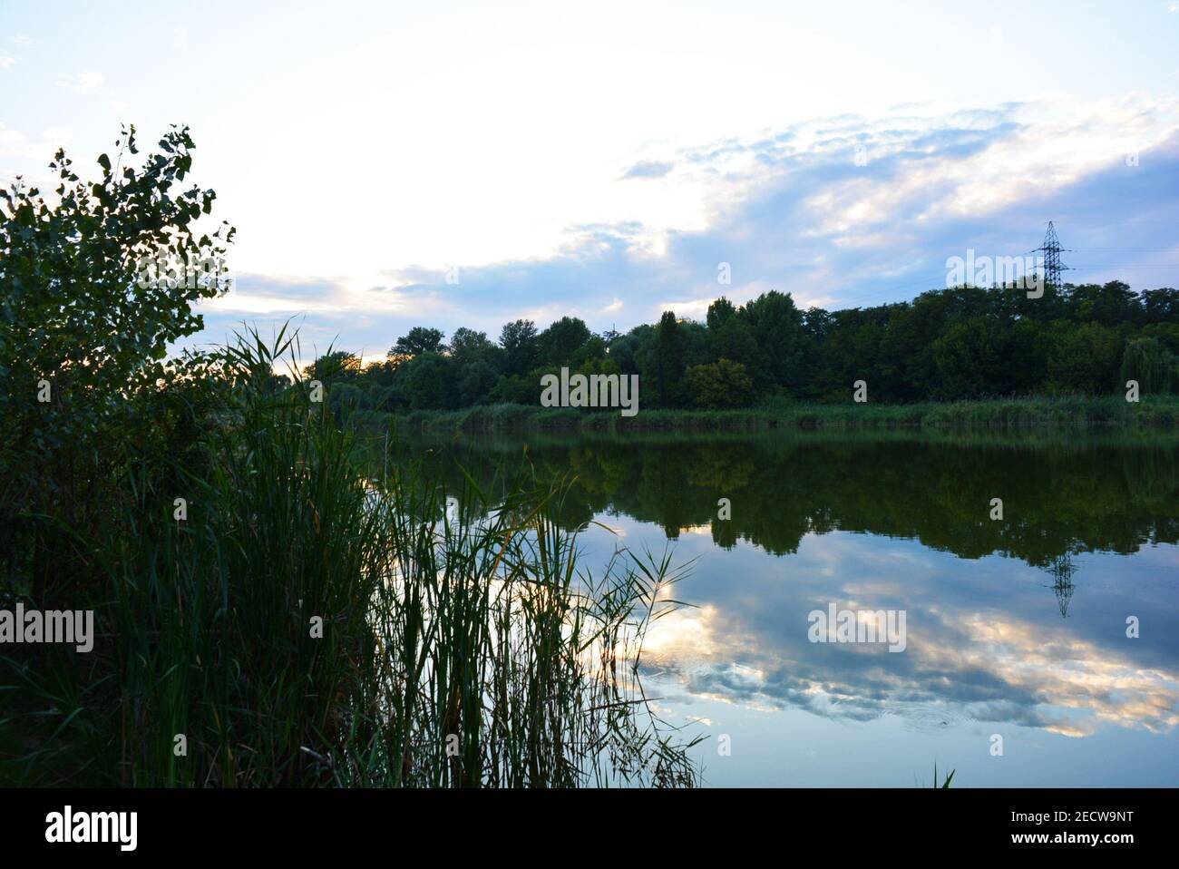 Kleiner natürlicher See Pishchevoye mit grünen Hügeln, ungewöhnlichen Bäumen, Schilf und Vegetation im Bereich des Wohngebietes des Nordens und der Samara Stockfoto