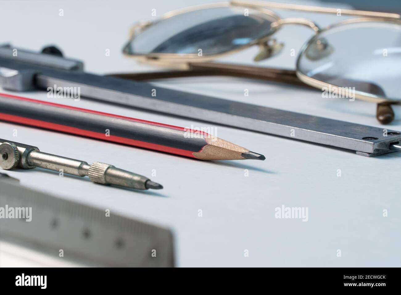 Gläser und Zeichenbedarf liegen auf dem Tisch im Schulzimmer. Universitäre akademische Fächer für Geometrie.Lineal, Kompass, Bleistift, Bremssattel und g Stockfoto