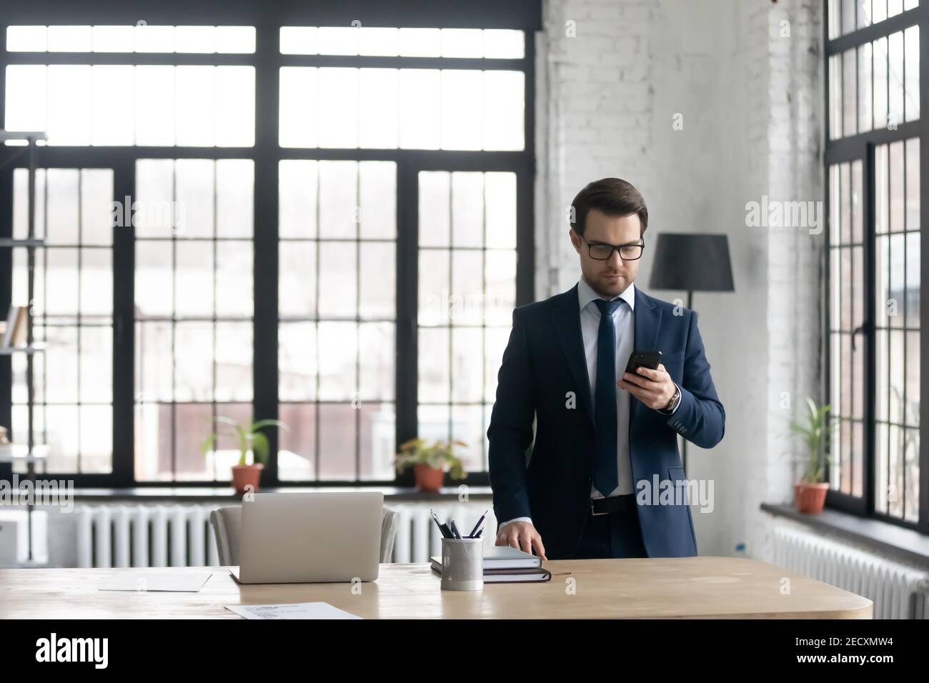 Kaukasischen Geschäftsmann im Anzug verwenden Smartphone im Büro Stockfoto