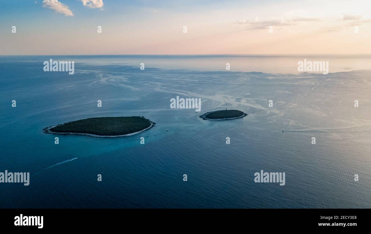 Drohnenansicht der Schwesterinseln Dvije Sestrice Velika und Mala vor der Küste neben Rovinj in Kroatien Stockfoto