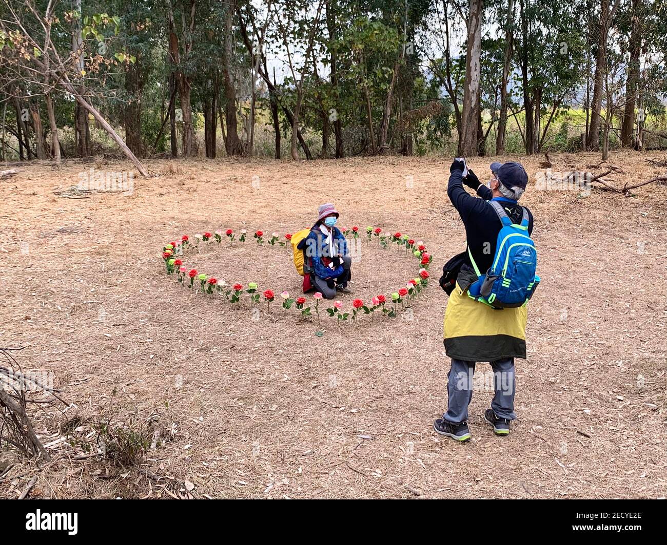 Ein älteres Paar fotografiert auf einem herzförmigen Blumengeck auf dem Land von Hongkong. Am Valentinstag feiern die Menschen unter dem Einfluss von COVID-19. Viele entscheiden sich, mit ihren Lieben auf dem Land zu verbringen, wo sie weniger Menschen sind, um eine bessere soziale Distanzierung zu geben. Stockfoto