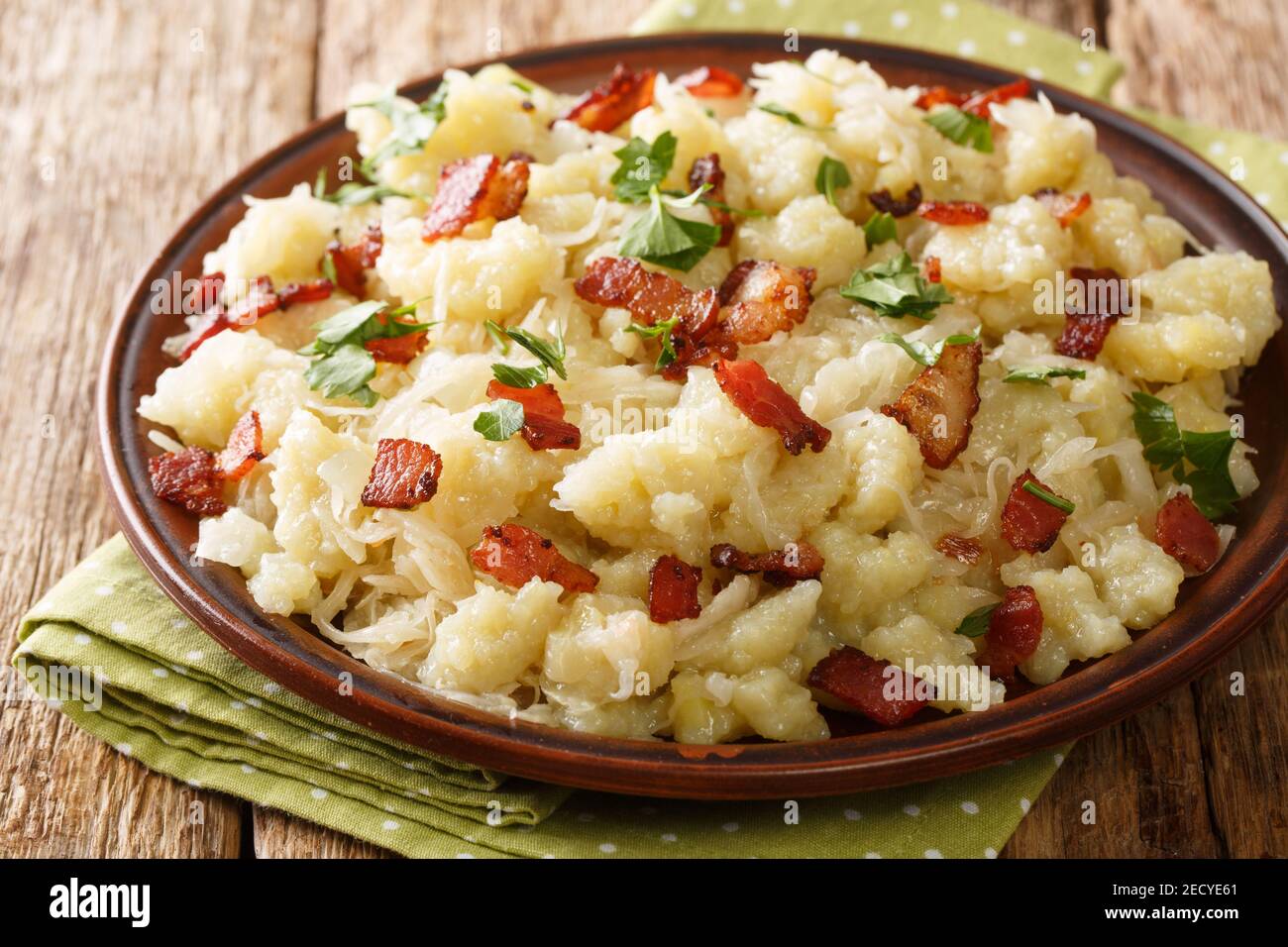 Slowakische Halusky geriebene Kartoffelknödel mit Sauerkraut und Speck in der Nähe in der Platte auf dem Tisch. Horizontal Stockfoto