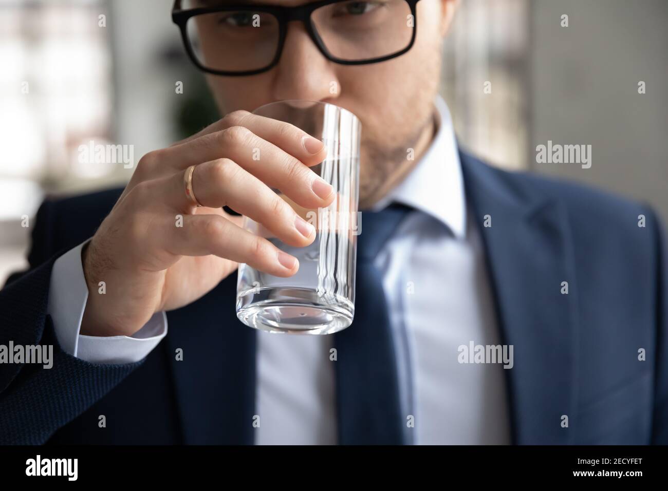 Nahaufnahme eines männlichen Mitarbeiters, der sauberes Mineralwasser trinkt Stockfoto