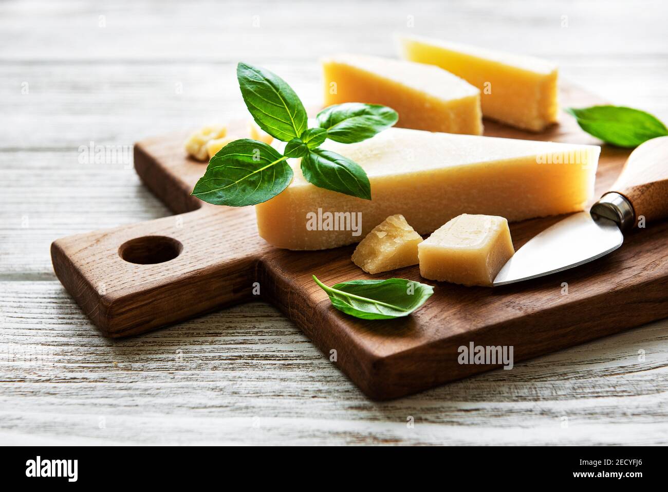 Stück Parmesankäse auf einem Holzbrett Stockfoto