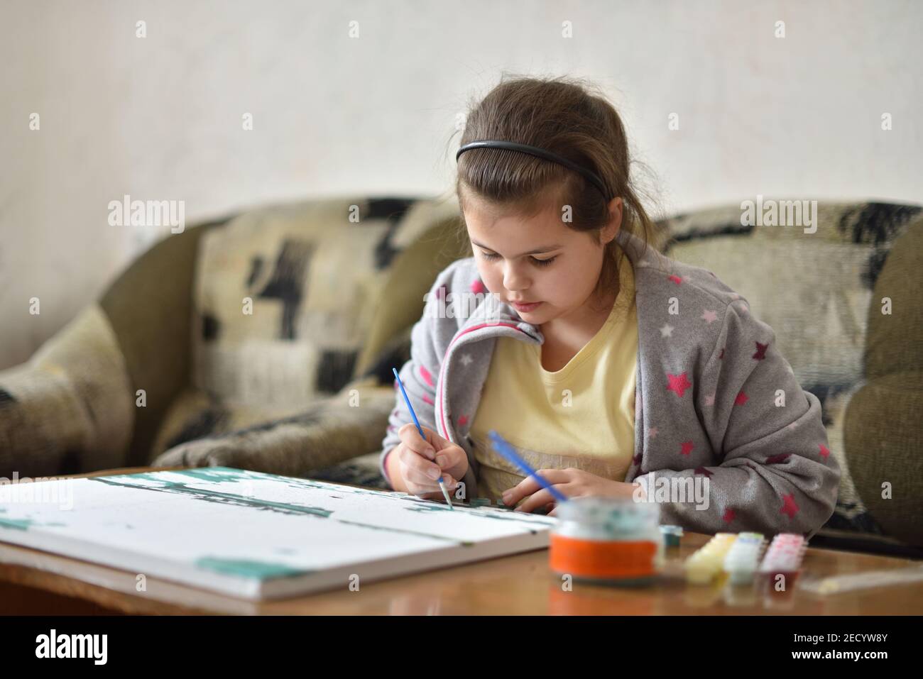 Kind Mädchen zeichnet ein Bild mit Farben zu Hause Stockfoto