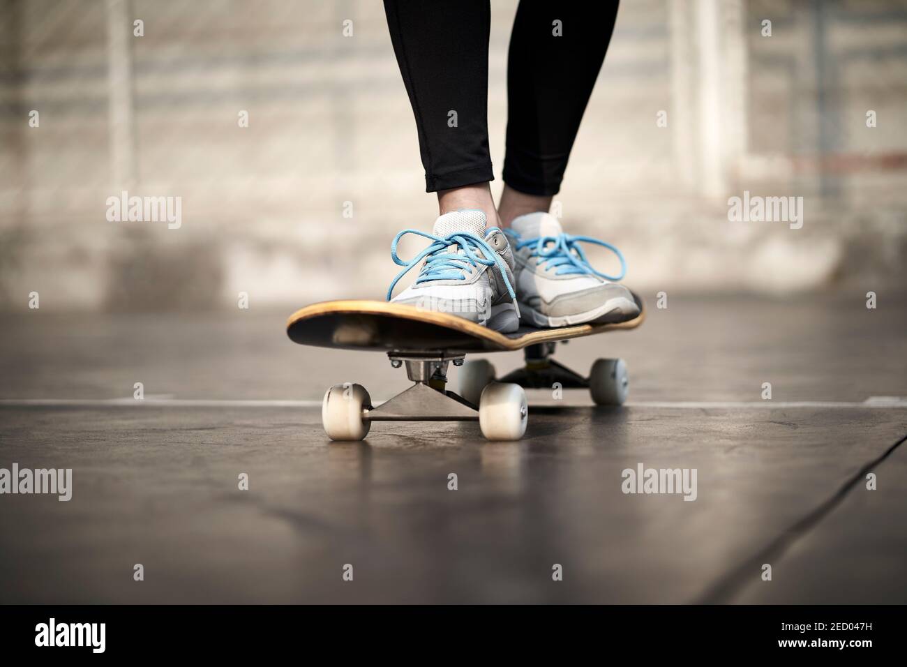 Nahaufnahme der Füße einer jungen Frau beim Skateboarden im Freien Stockfoto