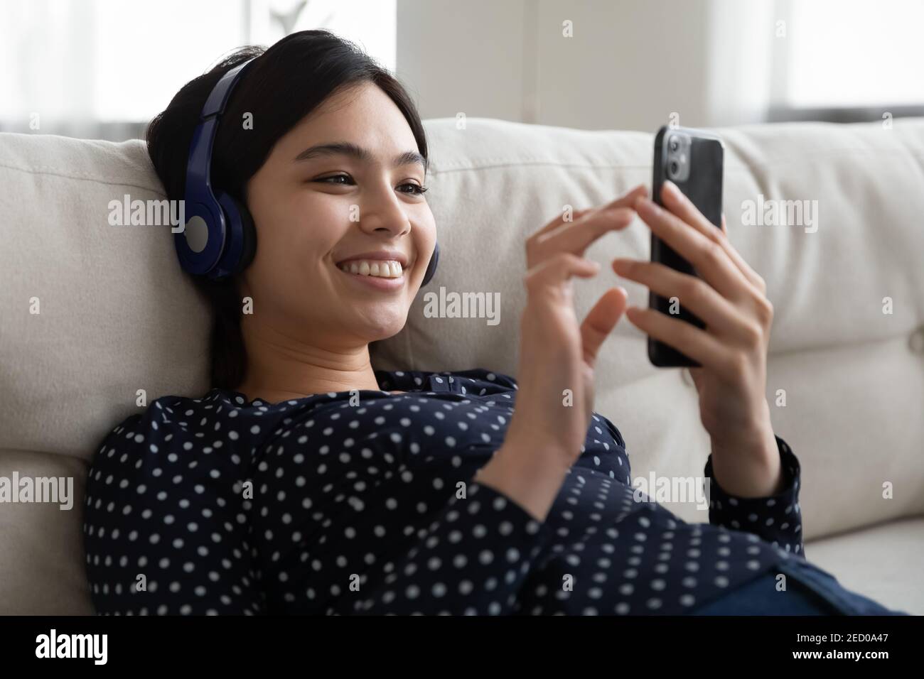 Glücklich asiatische weiblich entspannen im Headset-Chat online auf dem Smartphone Stockfoto
