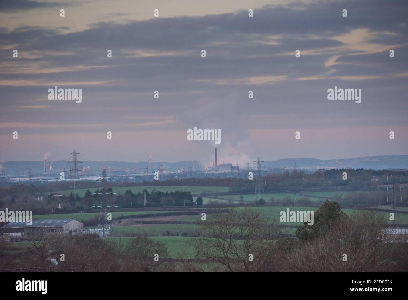 Blick über die Landschaft zum industriellen Avonmouth und dem Seabank Kraftwerk, das Dampf abpumpt, über Windturbinen und Strommasten Stockfoto