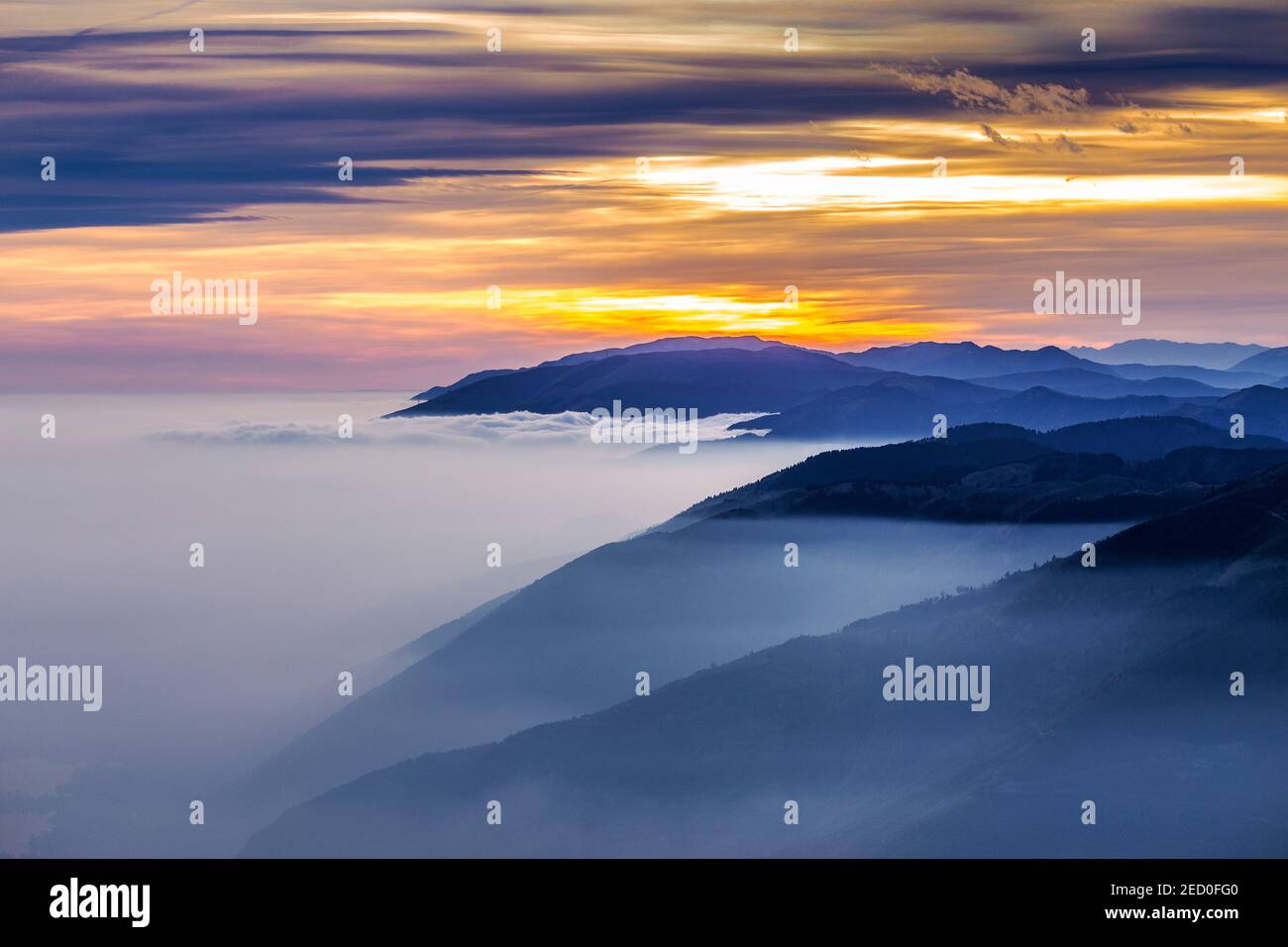 Sonnenlicht Farben bei Sonnenuntergang. Hügellagen, venezianische Voralpen. Bunte Wolken. Farbige Sonnenuntergangslandschaft. Venetien. Italien. Stockfoto