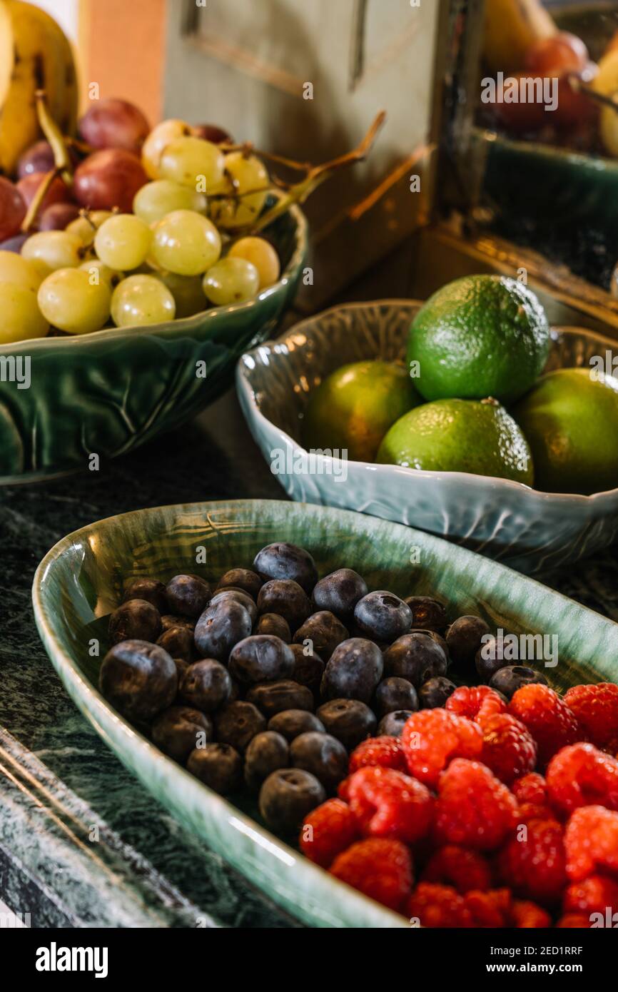 Verschiedene reife Früchte und leckere Beeren auf Tellern serviert Tisch für Frühstücksbuffet Stockfoto