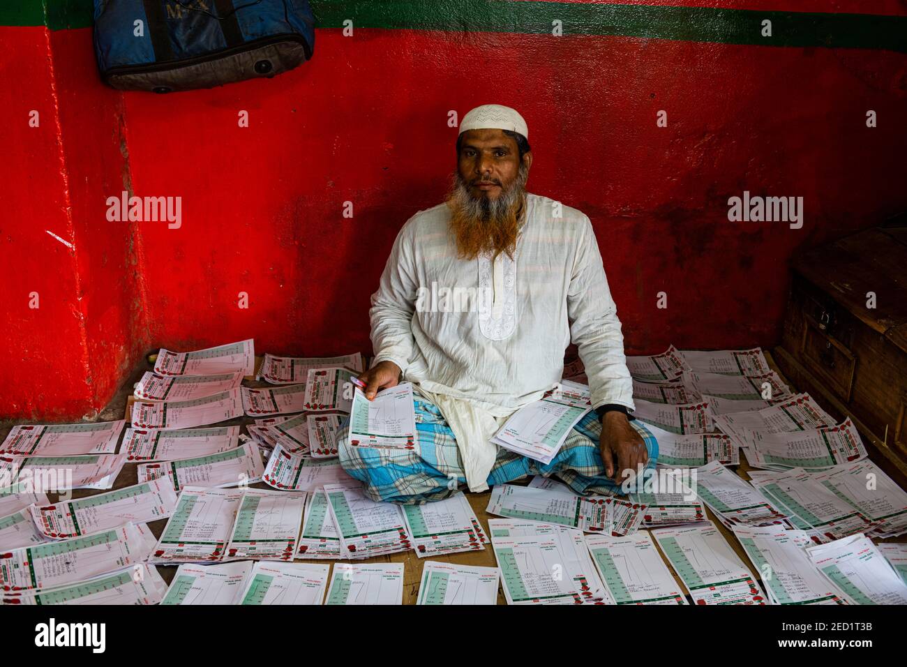 Mann, der zwischen Zeitungen sitzt, Dhaka, Bangladesch Stockfoto