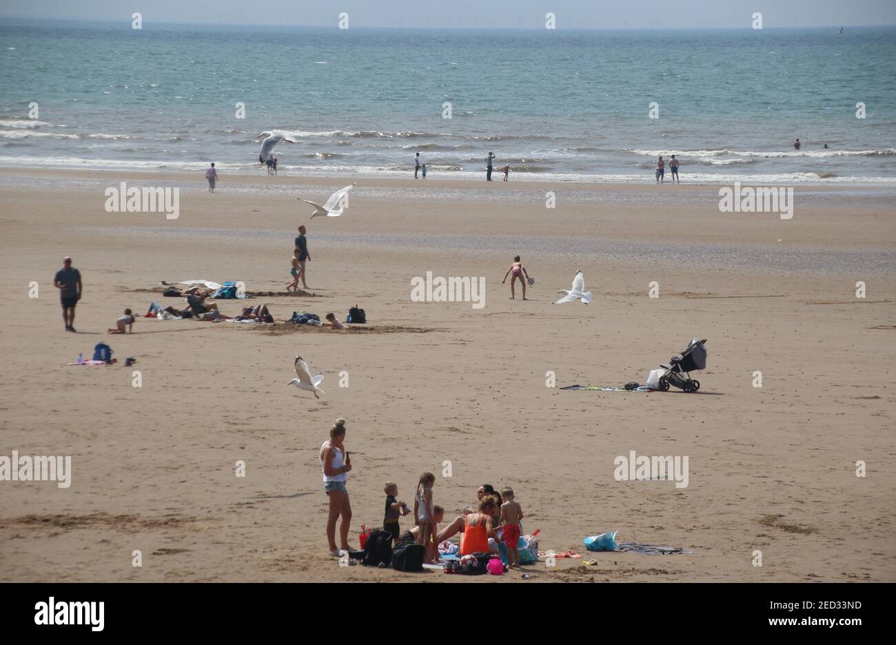 Der Sandstrand von St. Bees und das irische Meer. Viele Menschen genießen den sonnigen Tag am Strand. Westküste von England, in der Nähe des Lake District. Europa. Stockfoto