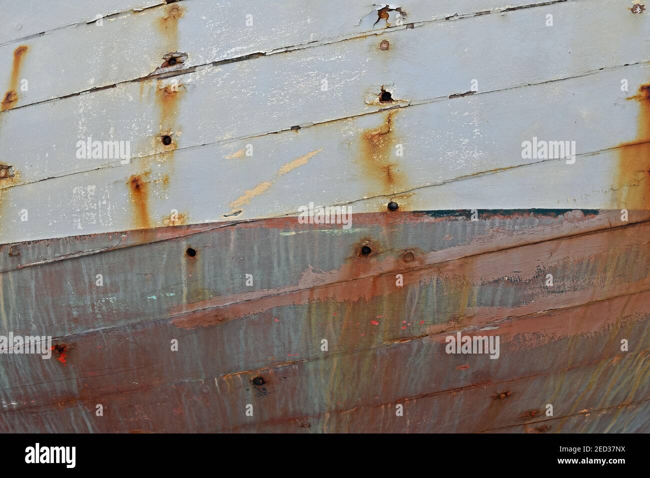 Nahaufnahme des Bootes Rumpf mit Rostspuren und Wetter Schäden an lackierten Holzplanken Stockfoto