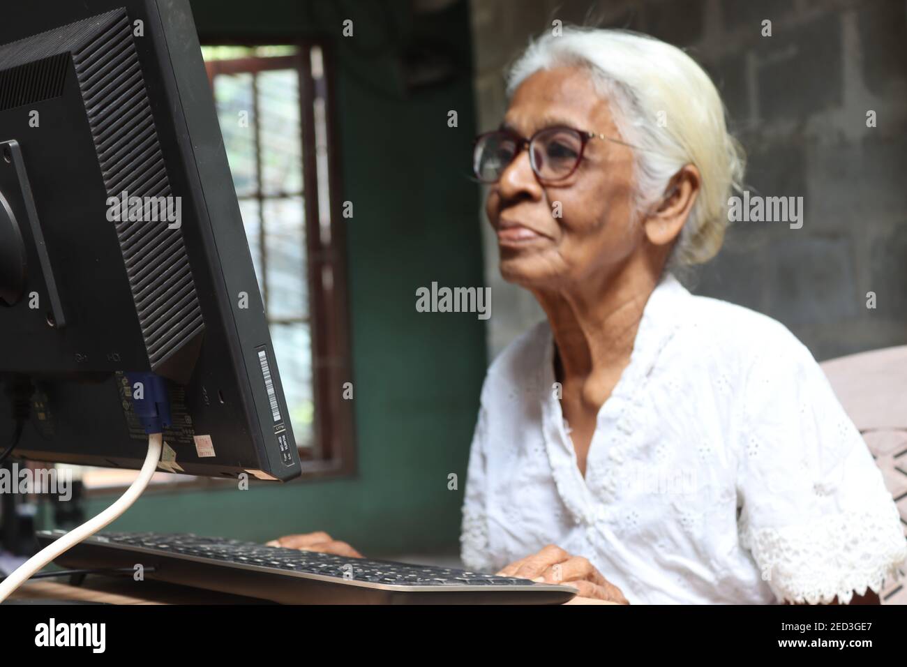 Unter dem Thema "Seniors using current Technology" nutzt Großmutter moderne Technik und Kommunikation zu Hause. Stockfoto