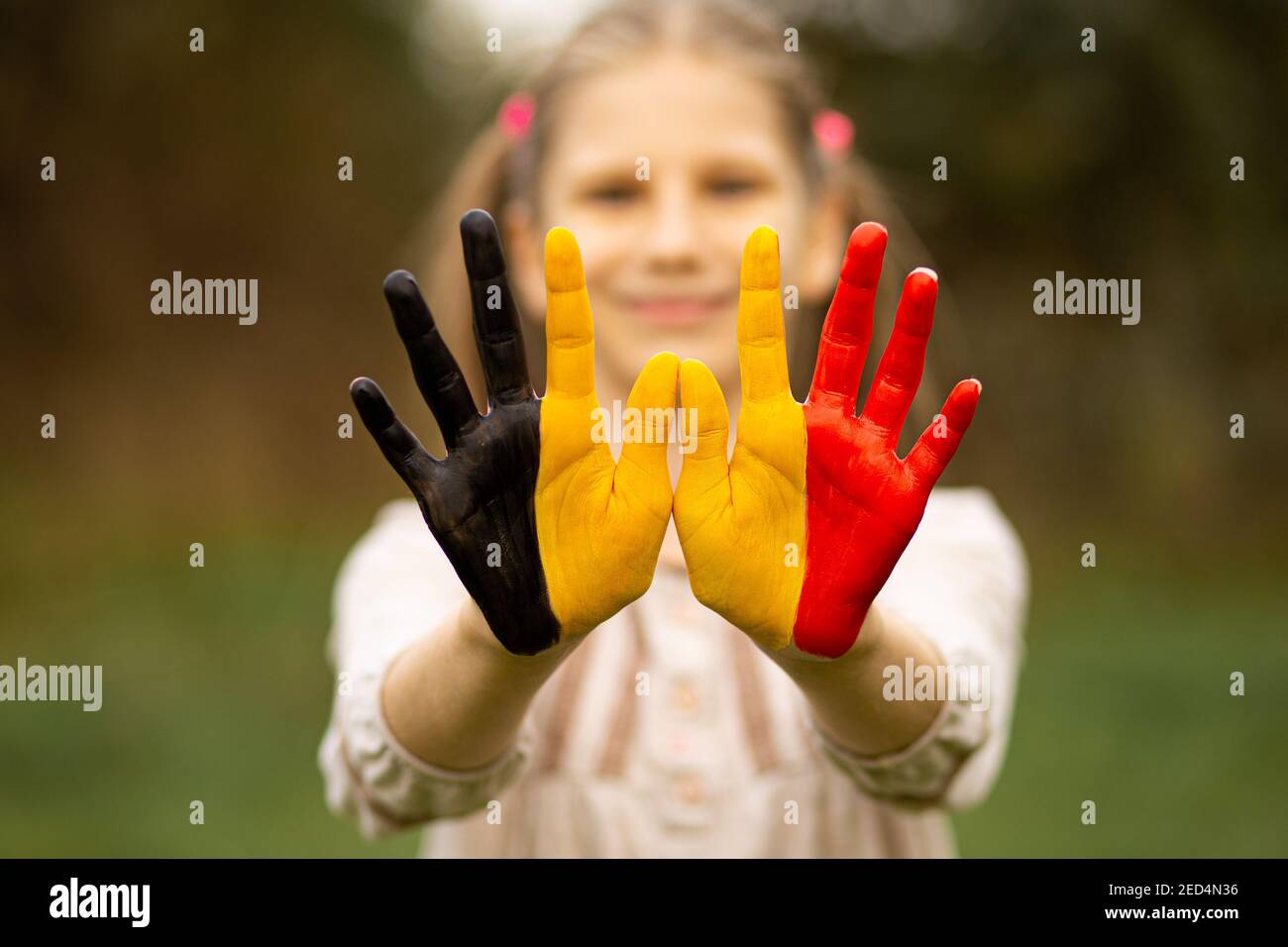 Kind Mädchen zeigen Hände in Belgien Flagge Farben zu Fuß im Freien gemalt, konzentrieren sich auf die Hände Stockfoto