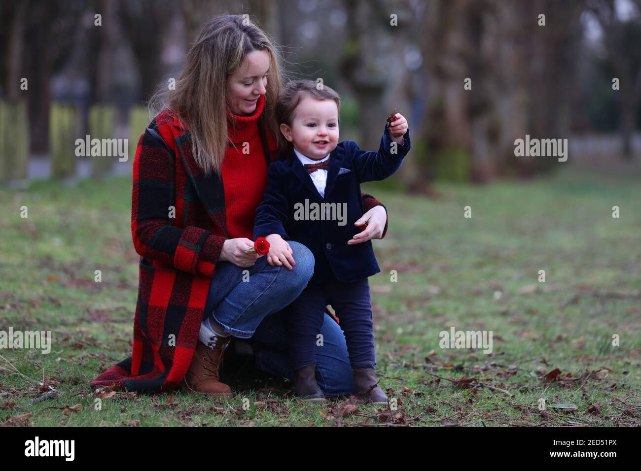 Ein kleiner einjähriger Junge namens Oscar verkleidet mit einer Rose in der Hand für Valentinstag. Chichester, West Sussex, Großbritannien. Stockfoto