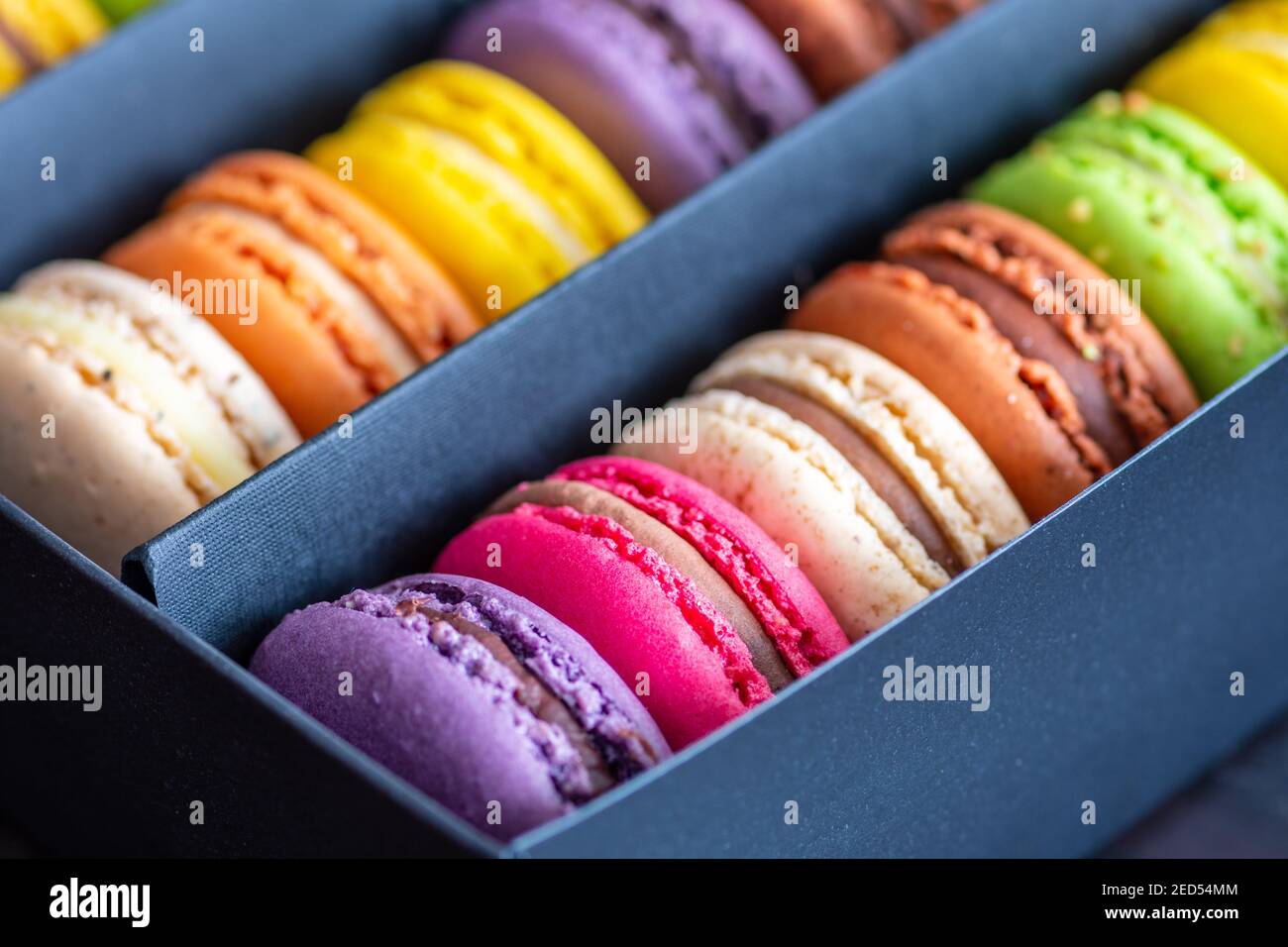 Verschiedene bunte Makronen oder französische Makronen in einer Reihe in einer Geschenkbox, süßes Baiser-Konfekt aus Eiweiß, Puderzucker, granuliert Stockfoto