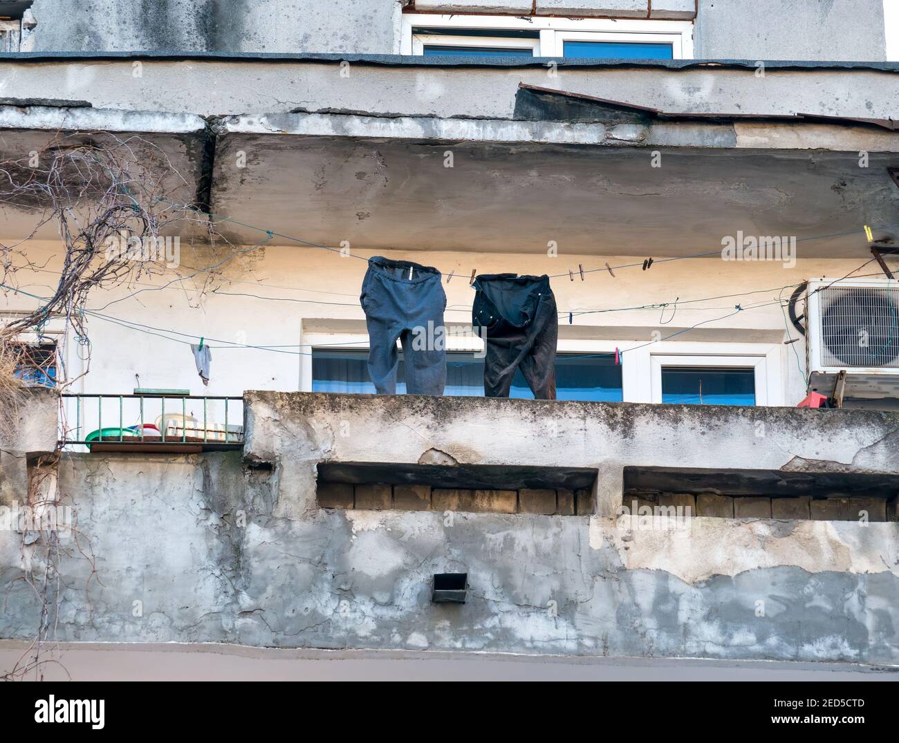 Altes, abgenutztes kommunistisches Wohnhaus in Bukarest, Rumänien. Wäsche zum Trocknen auf dem Balkon. Stockfoto