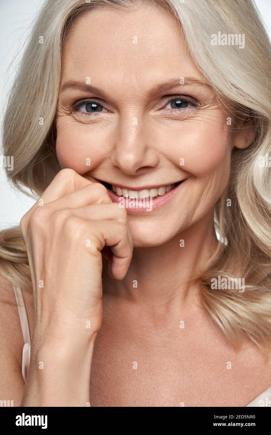 Glückliche Frau mittleren Alters, die Kamera anschaut. Anti-Age-Gesichtspflege, Nahaufnahme Stockfoto