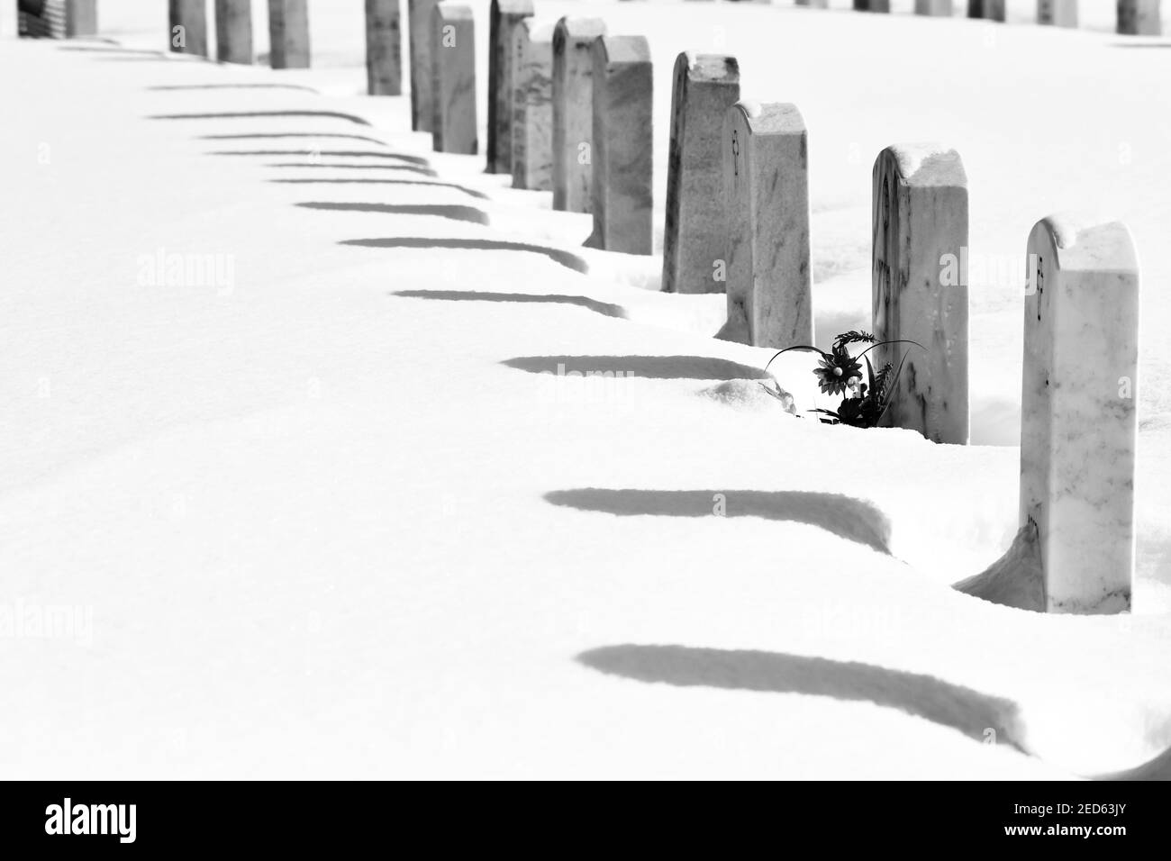 Reihe von Friedhofdenkmal Marker im Winterschnee Stockfoto