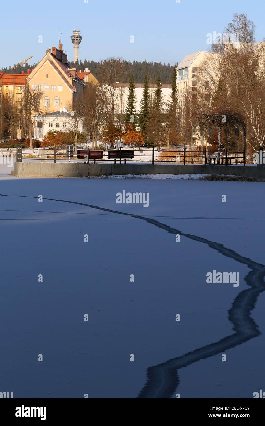 Schöne Winteransicht mit gefrorener Oberfläche des Sees Valkeinen und Gebäuden um ihn herum, Kuopio, Finnland, November 2019. Sehr beliebte Sehenswürdigkeit! Stockfoto